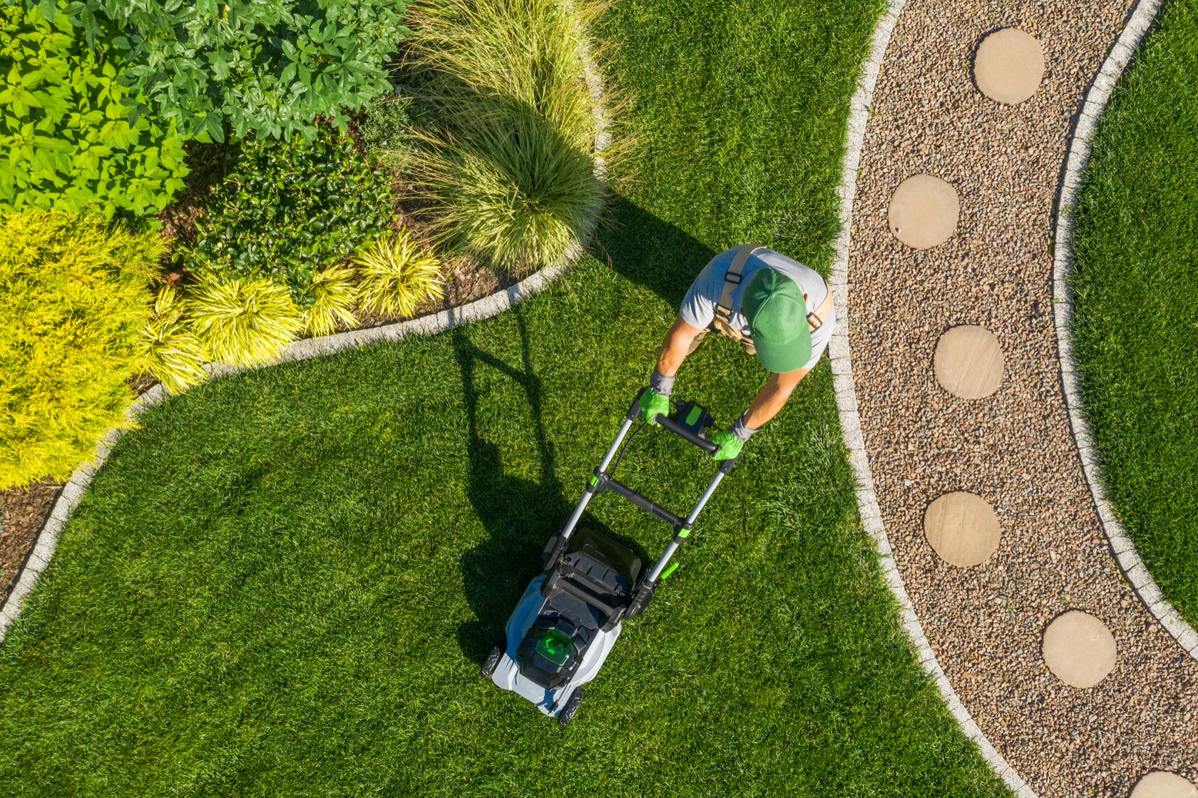 Clean side-yard walkway with low-water shrubs under a blue sky